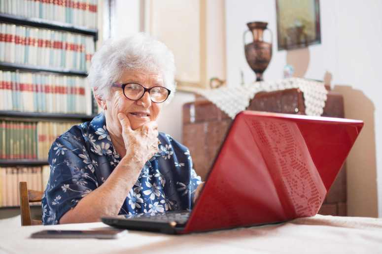 Surprised senior woman looking at laptop.